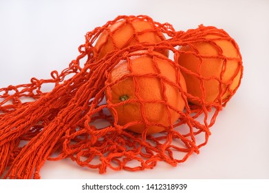 Handmade string bag with three oranges