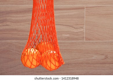 Handmade string bag with three oranges