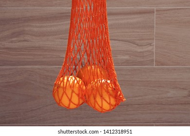 Handmade string bag with three oranges