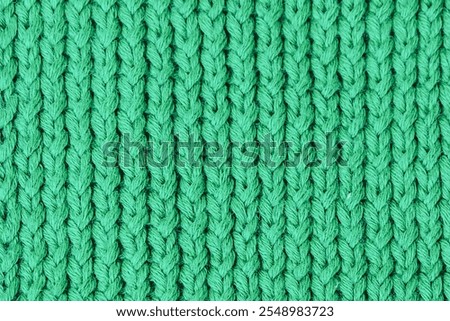 Handmade texture of knitted pattern made with green wool yarn