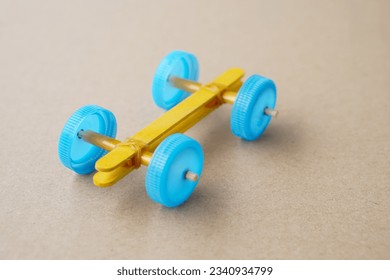 Handmade toy racing car made from ice cream sticks and bottle caps. Concept, Recycling kids toy.Easy to do, creative DIY craft that kids can do. Fun lesson to support kid imagination development.