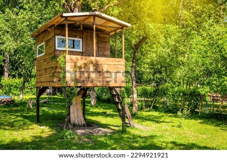 Handmade tree house in sunny green garden