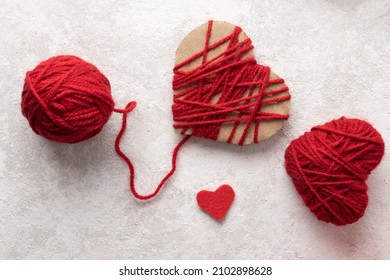 Handmade Valentine From Yarn On White Background, A Red Heart For Valentine's Day.