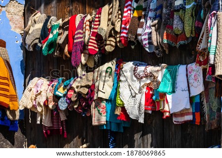 Handmade woolen knitted socks and clothes for sale designed by the locals, exhibited in front of their houses on a narrow street in Viscri, Romania, 2021