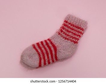 Handmade Woolen Merino Wool Socks On Pink Rose Background. Craft Store Concept