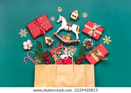 Handmade wrapped red, green gift boxes decorated with ribbons, snowflakes and numbers, Christmas decorations and decor in bag on green table Xmas advent calendar concept Top view Flat lay Holiday card