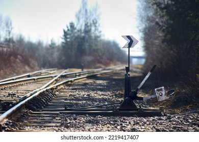 Hand-operated railroad switch with lever signal weight. Old railroad switch near spring sunny forest. Selective focus shot.