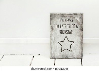 hand-painted motivational wooden sign in the white room NEVER TOO LATE TO BE ROCKSTAR