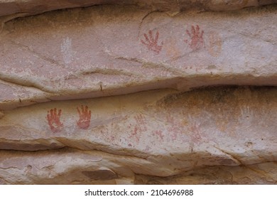 Handprints In Red, White And Yellow, Left By Ancient First Nation People, On A Sandstone Wall In The Bears Ears National Monument, Utah USA.