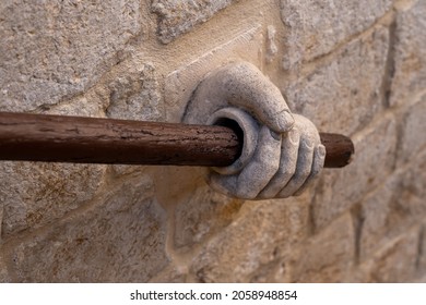 A Handrail Banister Made Of A Sculptured Hand With A Wood Rod