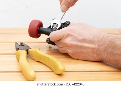 Hands adjusting nuts with wrench and tools on table