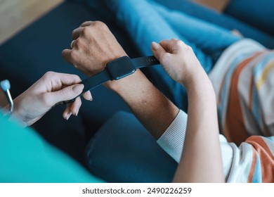 Hands adjusting a smartwatch for health monitoring. Showcases digital healthcare solutions, wearable technology for seniors, and the role of caregivers in implementing modern health tracking devices. - Powered by Shutterstock