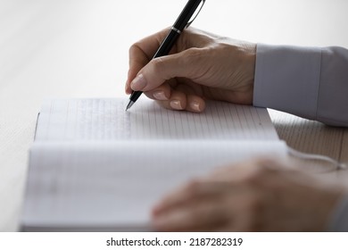 Hands Of Adult Woman Writing Notes In Notebook. Side View, Close Up Of Page With Handwritten Text And Pen. Mature Female Writer, Professional Author Working On Book