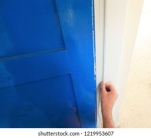 Hands Affixing Adhesive Rubber Draft Proofing To A Door Frame.