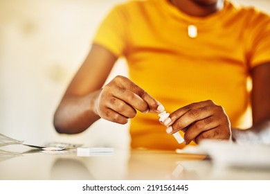 Hands Of African Female With HIV And Aids At Home Blood Self Test Kit Sitting At A Desk Waiting To Check For Results. Closeup Of Young Afro Woman With Medicine Or Pills For A Medical Condition.