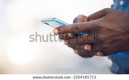 Hands of an african man on a phone networking, doing research on the internet or typing a message. Closeup of a black guy browsing on social media, mobile app or an online website with a smartphone.