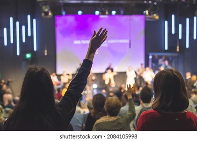 Hands in the air of people who praise God at church service - Shutterstock ID 2084105998