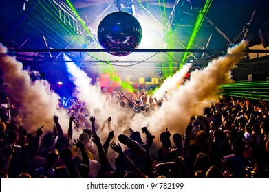 Hands In Air Rave With Smoke Machine and Laser Crowd - Nightclub - Shutterstock ID 94782199