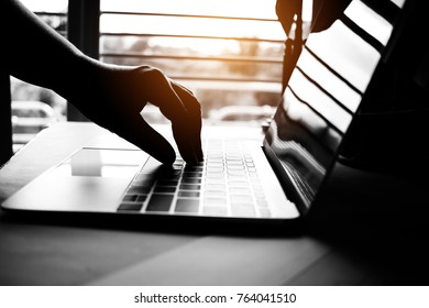 hands of anonymous hackers typing code on keyboard of laptop for remotely reach and receiving personal information online networking, Internet Crime Payment Security Concept, Silhouette black white