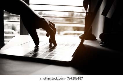 hands of anonymous hackers typing code on keyboard of laptop for remotely reach and receiving personal information online networking, Internet Crime Payment Security Concept, Silhouette black white