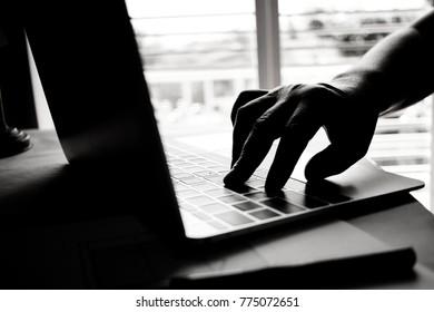 hands of anonymous hackers typing code on keyboard of laptop for remotely reach and receiving personal information online networking, Internet Crime Payment Security Concept, Silhouette black white