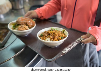 Hands of an anonymous woman holding a tray with bowls of traditional food consisting of chopped beef with rice, at the food market next to Chenghuang temple - Shutterstock ID 1535591789