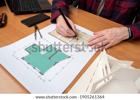 Hands of architect during work. Concept - work in an architectural bureau. Architect career. Man draws construction drawings. Apartment plan on paper. Career in architectural business.