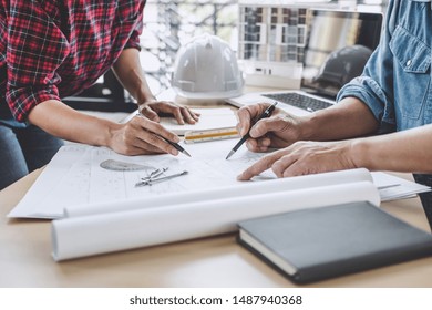 Hands of architect or engineer working on blueprint meeting for project working with partner on model building and engineering tools in working site, Construction and structure concept.