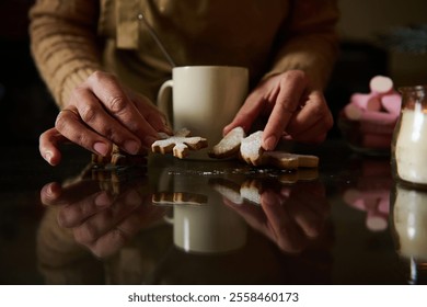 Hands arranging powdered sugar cookies near a cup, creating a cozy warm atmosphere. - Powered by Shutterstock