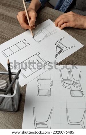 Hands of an artist sketching furniture. Creation of design of chairs and cabinets for the interior.