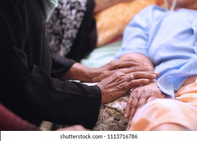 Hands of Asian Muslim woman holding  patient hand and encourage to thier cousin during Muslim celebrated of Eid al-Adha. After morning prayers while they are visits to friends and family.