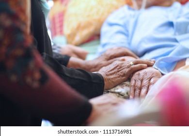 Hands of Asian Muslim woman holding  patient hand and encourage to their cousin during Muslim celebrated of Eid al-Adha. After morning prayers while they are visits to friends and family.