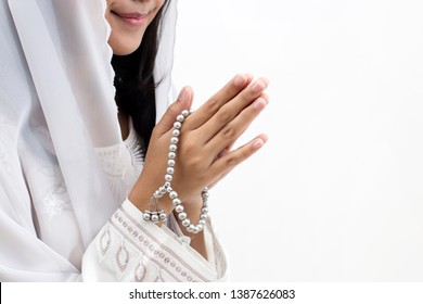 Hands of Asian muslim woman wearing prayer beads welcoming guests / Ied Fitr Greeting in white background