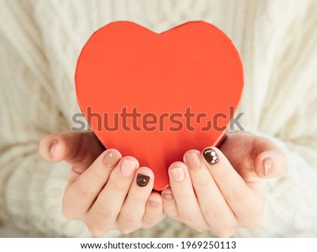 Hands of an Asian woman giving a heart gift