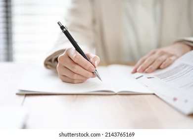 Hands of an Asian woman studying in a coworking space - Shutterstock ID 2143765169