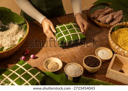 Hands assembling Chung cake with sticky rice and mung bean filling, showcasing Vietnamese Tet rituals and ancestral Lunar New Year cooking traditions