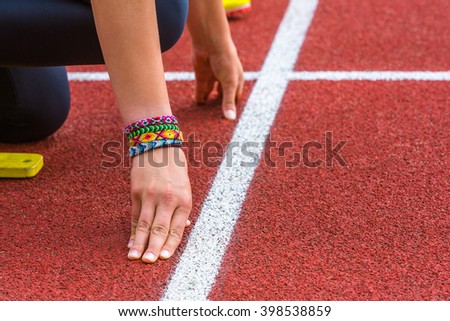 hands of a athlete on the race line with a friendship bracelet