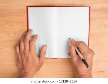 Hands Of The Author Giving Autograph On The Page Of His Book Top View