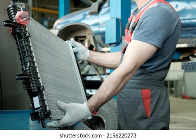 In The Hands Of An Auto Mechanic, An Automobile Radiator. Inspection And Control Of Compliance, Integrity Of The Spare Part. Repair And Maintenance In The Car Center.