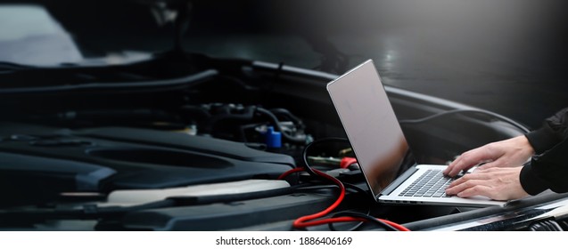 Hands Of Auto Mechanic Using Computer For Diagnostics Engine Working And Repairing Car In A Garage. Blur Repair Service In Background. Wide Panoramatic Banner With Empty Space For Copy Text.