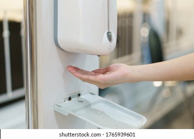 Hands with automatic sanitizer liquid spray machine, touchless dispenser. - Shutterstock ID 1765939601