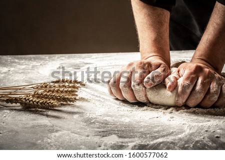 Hands of baker kneading dough isolated on black background. prepares ecologically natural pastries.