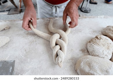 Hands of baker preparing dough on wooden table. France. - Powered by Shutterstock