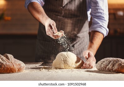 hands of the baker's male knead dough - Shutterstock ID 1091502968