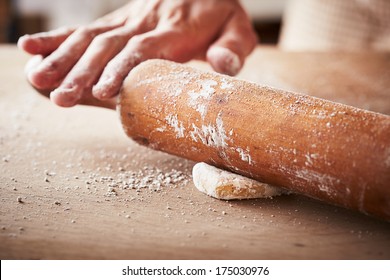 Hands Baking Dough With Rolling Pin On Wooden Table