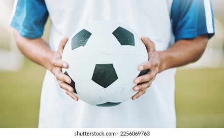 Hands, ball and soccer player ready for sports match, game or competition on the outdoor field. Hand holding round sphere object for sport, training or practice in physical activity outside in nature - Shutterstock ID 2256069763