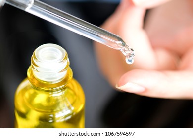 hands of a beautiful woman Dropping serum collagen moisturizer of face into clear yellow bottle soft light background. Protector skin Treatment facial essence oil, Vitamin C. Beauty and spa Concept. - Shutterstock ID 1067594597