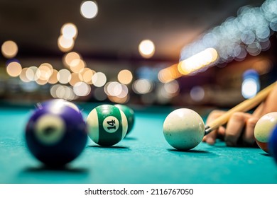 hands of a beautiful young slender girl beautifully chasing billiard balls on a spacious table in the billiard room. Billiards concept