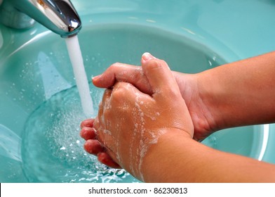 Hands being washed in a green sink