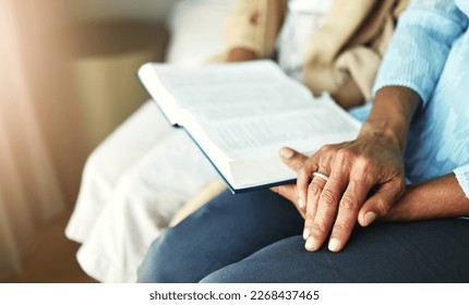 Hands, bible and senior couple praying in their home together for scripture, faith and trust. Family, worship and praise with elderly man and woman united in prayer, holy or gratitude to Jesus Christ
